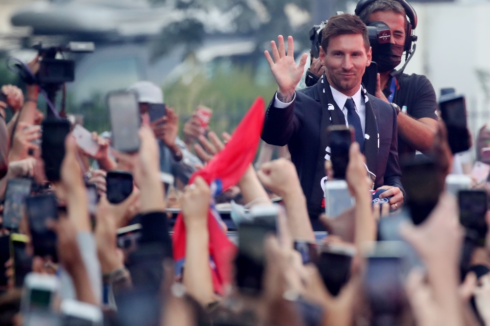 Paris St Germain's Lionel Messi gestures to fans outside the stadium after the press conference Reuters/Yves Herman