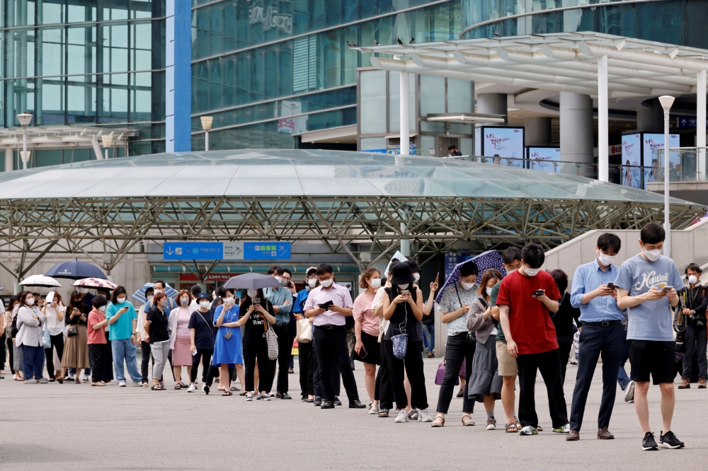 People wait in line for a coronavirus disease (COVID-19) test at a testing site, temporarily set up at a railway station in Seoul, South Korea, July 7, 2021. REUTERS/ Heo Ran/File Photo