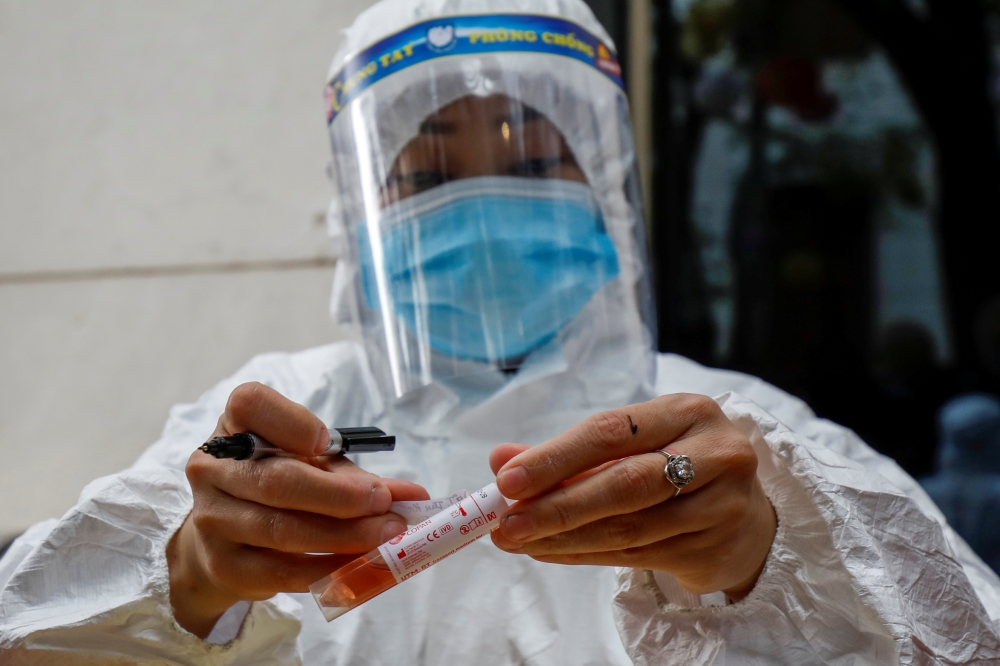 A health worker wearing a protective suit labels a sample tube at the National Convention Center, the venue for the 13th National Congress of the Communist Party of Vietnam, during the coronavirus disease (COVID-19) outbreak in Hanoi, Vietnam January 29, 