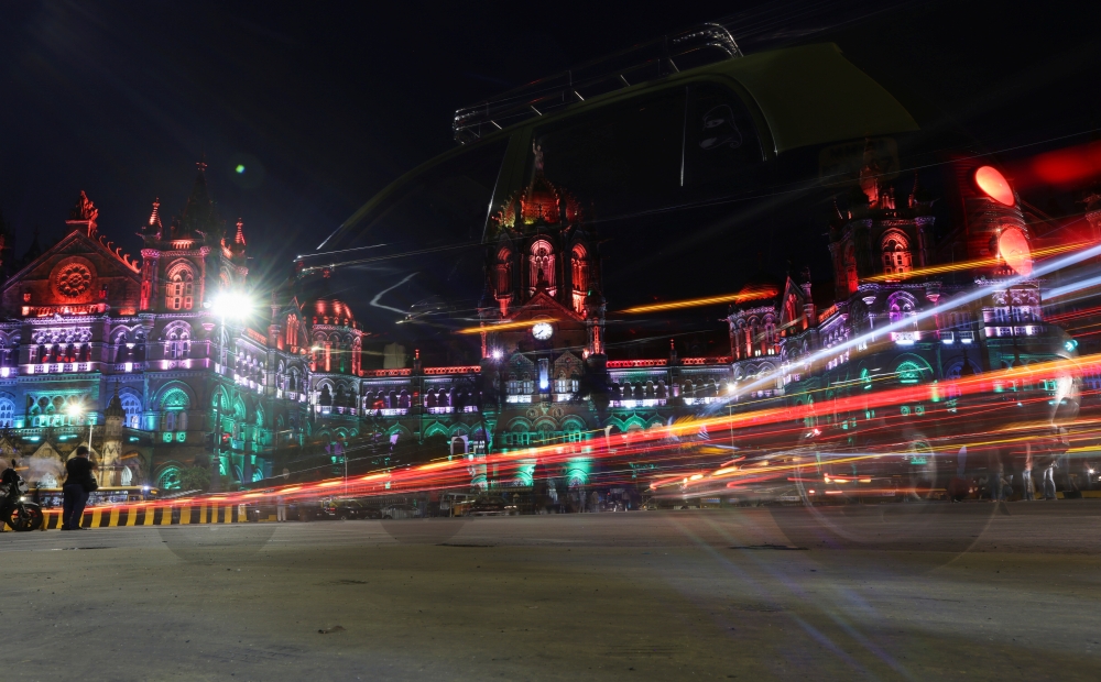 Traffic moves in front of the Chhatrapati Shivaji Maharaj Terminus (CSMT) building as it is illuminated in the colours of India's national flag on the eve of the 75th Independence Day in Mumbai, India, August 14, 2021. Reuters/Francis Mascarenhas
