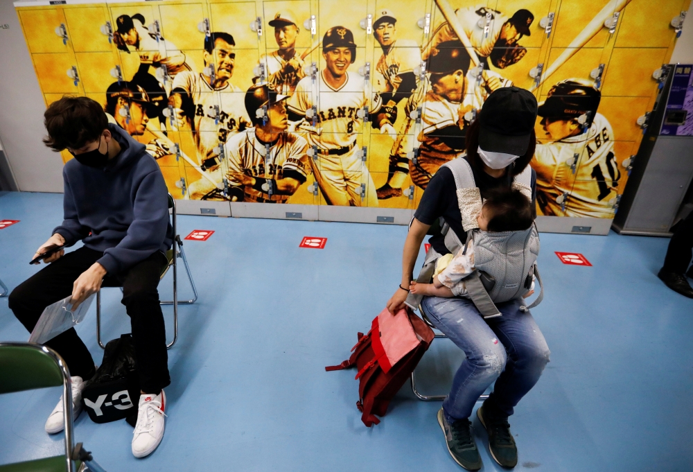 People wait for consultation after receiving the coronavirus disease (COVID-19) vaccine at the Tokyo Dome, the home ground of the Japanese professional baseball team Yomiuri Giants which is being used as a large-scale COVID-19 vaccination center, in Tokyo