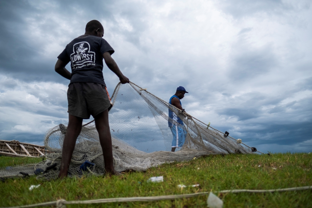 Two fishermen secure a fishing net on land, as Tropical Depression Grace approaches, after Saturday's 7.2 magnitude quake, in Les Cayes, Haiti August 16, 2021. REUTERS/Ricardo Arduengo