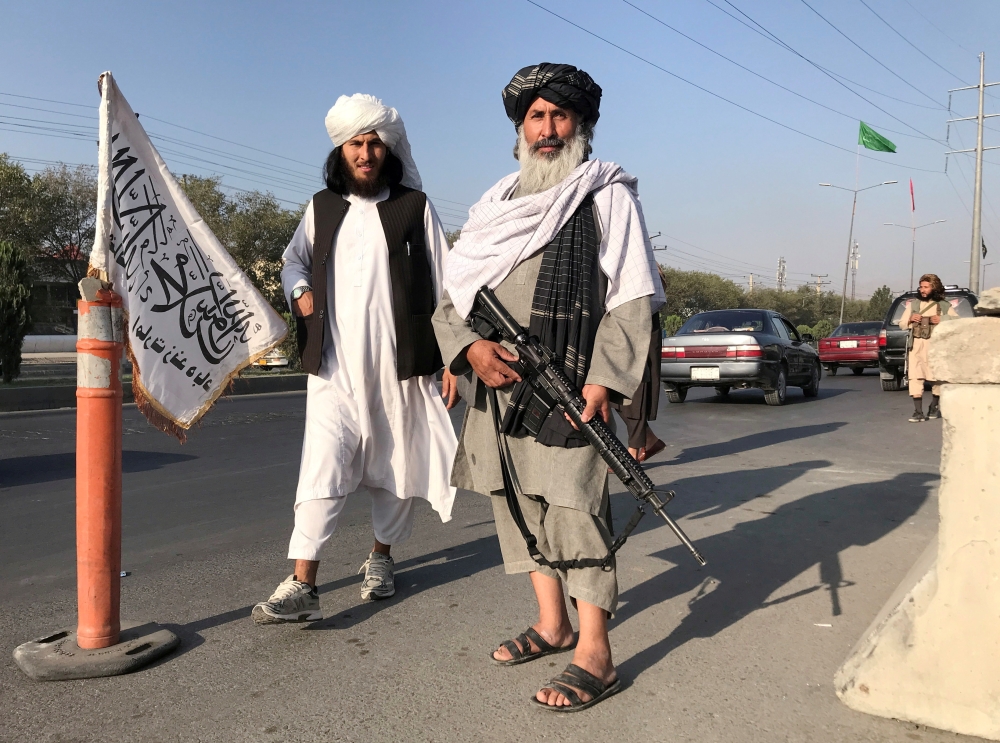 FILE PHOTO: A Taliban fighter holding an M16 assault rifle stands outside the Interior Ministry in Kabul, Afghanistan, August 16, 2021.REUTERS/Stringer