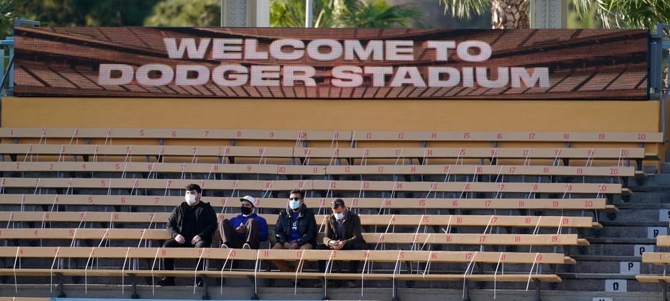 May 14, 2021; Los Angeles, California, USA; Fans in the left field bleachers at Dodger Stadium wear masks before the start of the Dodgers game against the Miami Marlins. As the CDC loosens restrictions many cites and venues are still requiring people to w