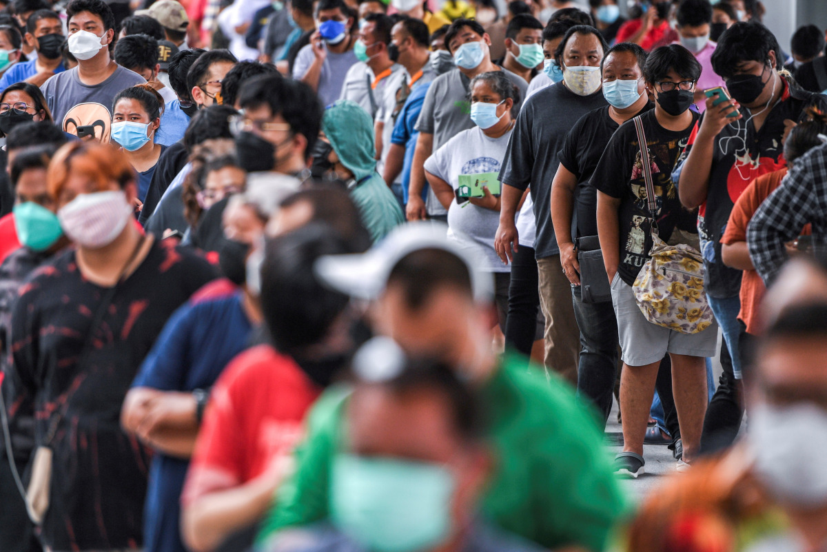 FILE PHOTO: People wearing protective masks queue outside the Central Vaccination Center as Thailand opens walk-in first dose of the AstraZeneca coronavirus disease (COVID-19) vaccination scheme for elders, people with a minimum weight of 100 kilograms an