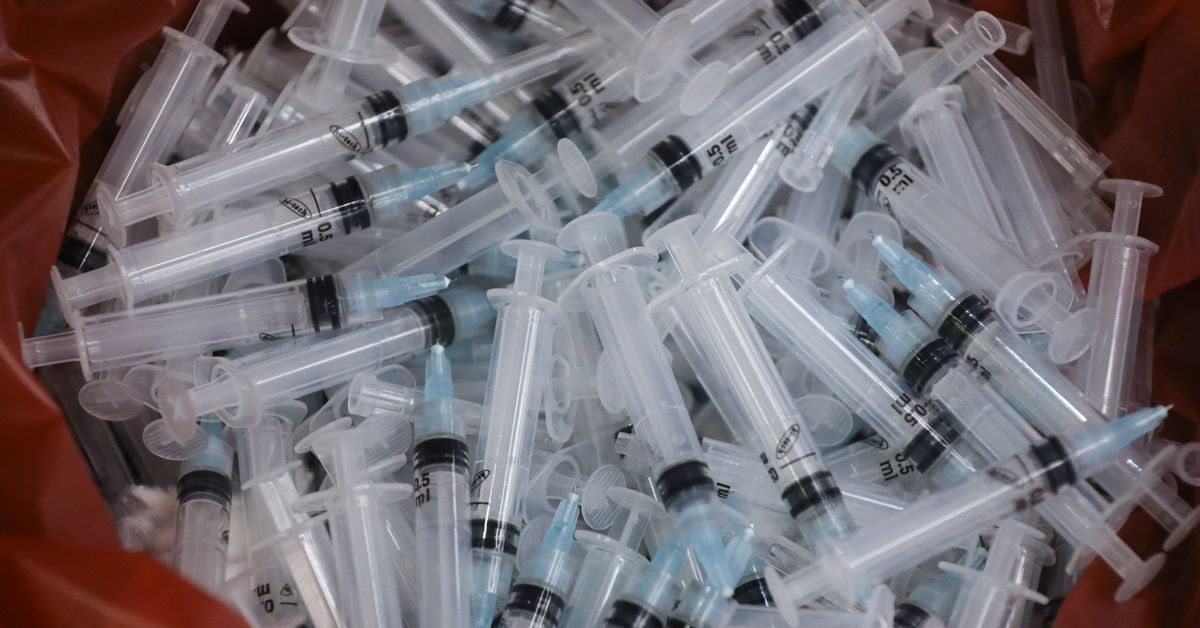 FILE PHOTO: Used syringes lie discarded in a bin after they were used to administer the coronavirus disease (COVID-19) vaccine in Mumbai, India, August 11, 2021. REUTERS/Francis Mascarenhas


