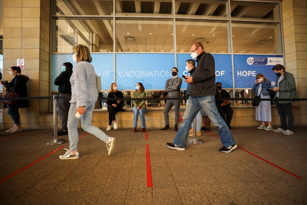 People queue outside a coronavirus disease (COVID-19) vaccination centre as the country opens vaccinations for everyone 18 years old and above in Cape Town, South Africa, August 20, 2021. REUTERS/Mike Hutchings