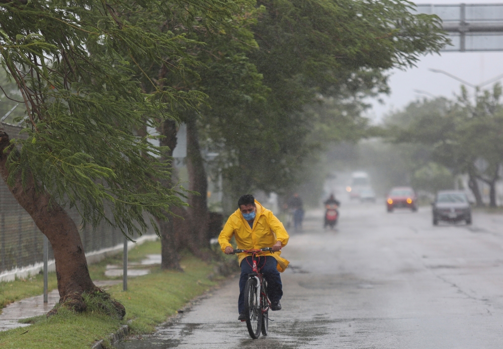 A man rides his bike in the rain after Hurricane Grace made landfall on the Yucatan Peninsula, in Merida, Mexico, August 19, 2021. REUTERS/Lorenzo Hernandez