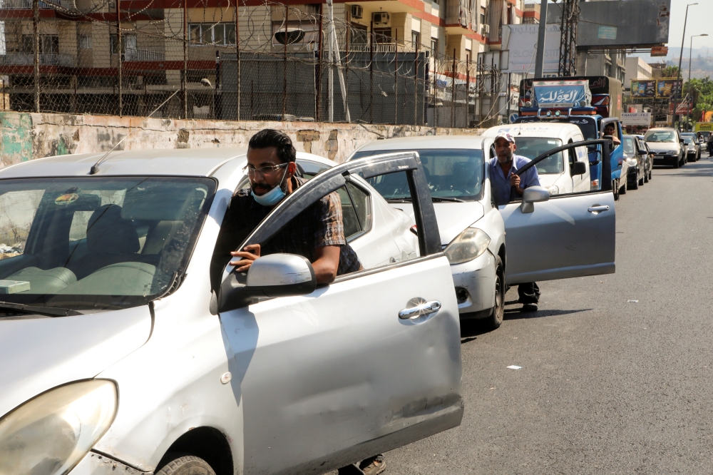 People push their cars due to a lack of fuel, near a gas station in Dora, Lebanon, August 17, 2021. Reuters/Mohamed Azakir/File Photo