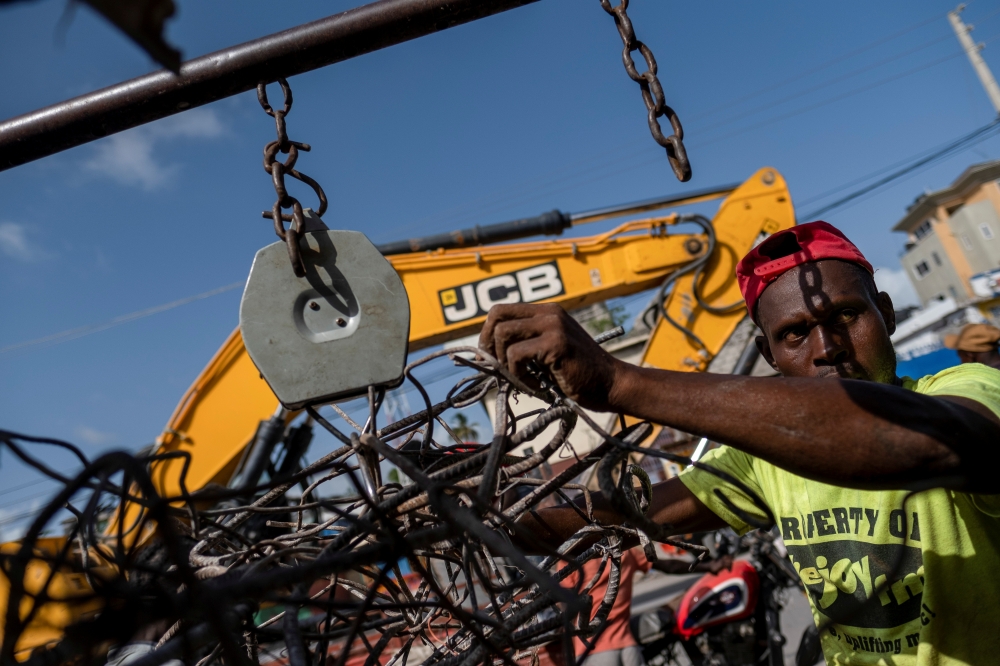 A man working at a metal recycler weights metal scavenged from houses destroyed after last week's 7.2 magnitude quake in Les Cayes, Haiti August 21, 2021. REUTERS/Ricardo Arduengo