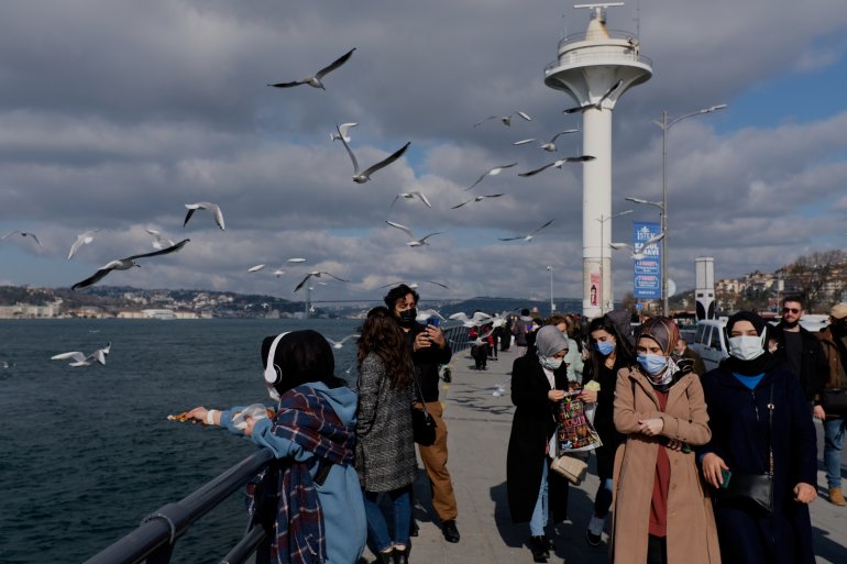 People wearing protective masks stroll by the Bosphorus, amid the coronavirus disease (COVID-19) outbreak in Istanbul, Turkey February 25, 2021. REUTERS/Murad Sezer
