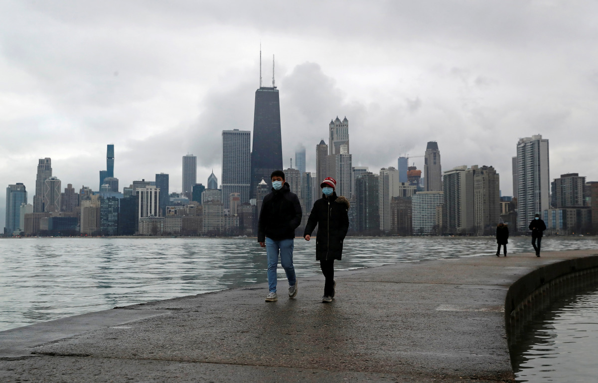 FILE PHOTO: People wearing protective face masks walk, as the global outbreak of the coronavirus disease (COVID-19) continues, along the shores of Lake Michigan in Chicago, Illinois, U.S., December 6, 2020. REUTERS/Shannon Stapleton/File Photo
