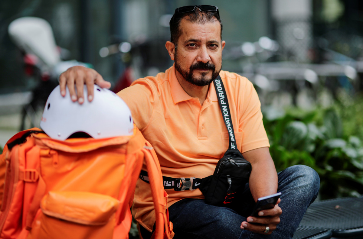Former Afghan Communication Minister Sayed Sadaat sits with his gear as he works for the food delivery service Lieferando in Leipzig, Germany, August 26, 2021. REUTERS/Hannibal Hanschke

