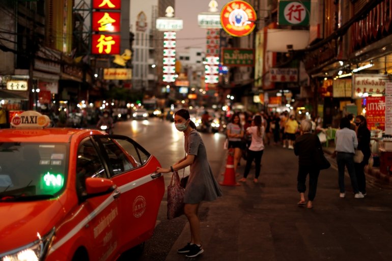 FILE PHOTO: A woman wearing a protective face mask enters a taxi in Chinatown, after the government started opening some restaurants outside shopping malls, parks, and barbershops during the coronavirus disease (COVID-19) outbreak in Bangkok, Thailand, Ma