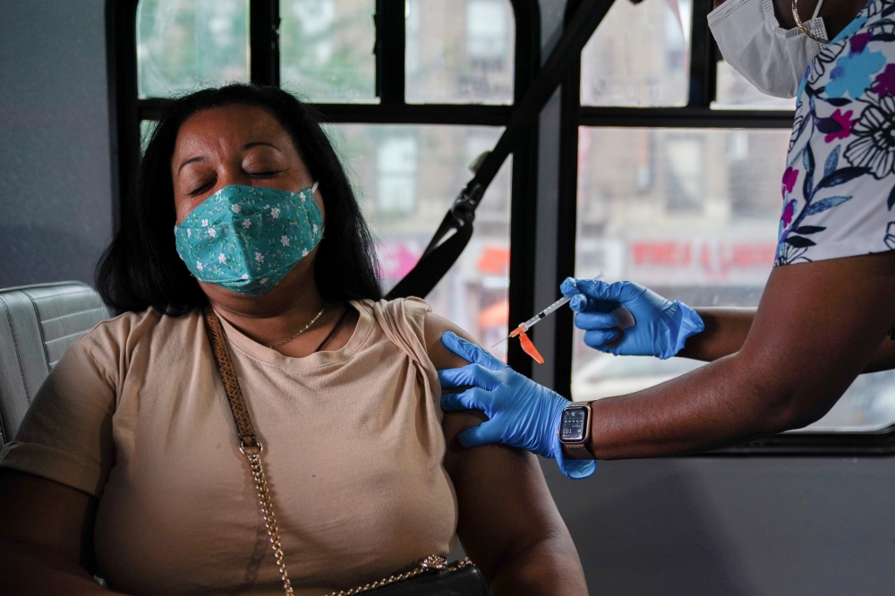 A person receives a dose of the Pfizer-BioNTech vaccine for the coronavirus disease (COVID-19), at a mobile inoculation site in the Bronx borough of New York City, New York, U.S., August 18, 2021. REUTERS/David 'Dee' Delgado/File Photo