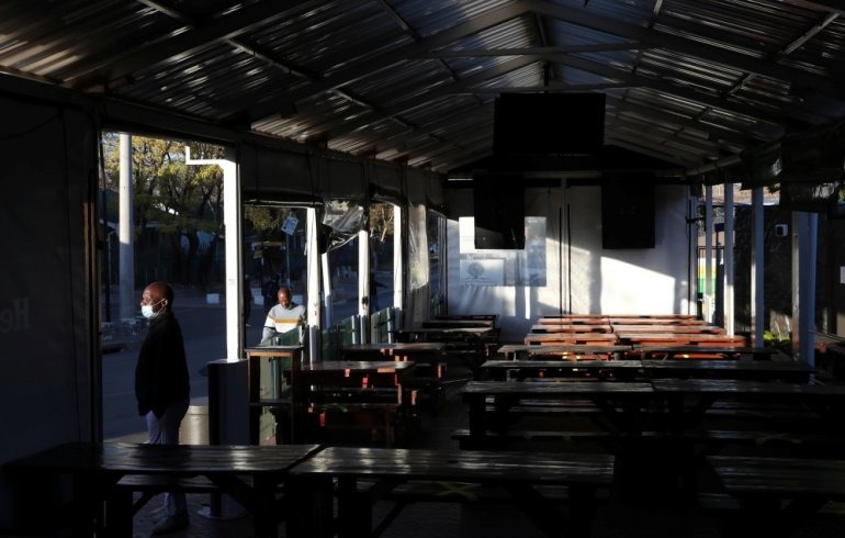 Empty seats are seen while a restaurant manager looks on during the coronavirus disease (COVID-19) outbreak as the country faces tougher lockdown restrictions in Soweto, South Africa, June 28, 2021. REUTERS/Siphiwe Sibeko