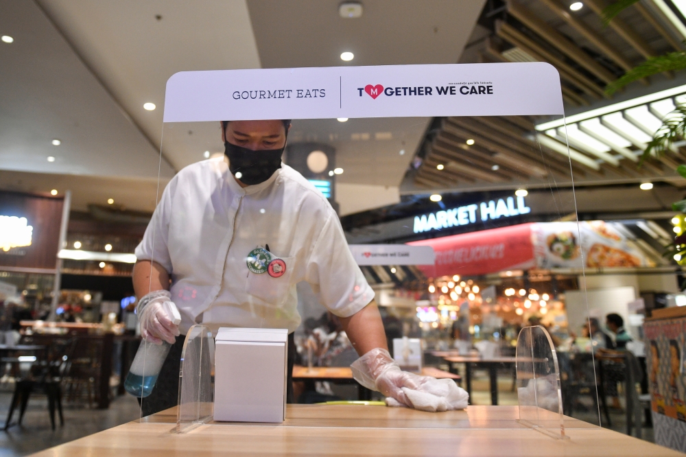 A staff member prepares to open a restaurant on the first day of coronavirus restrictions lift on retail and dining in Bangkok and other high-risk areas to revive the economy, as the country battles its worst coronavirus disease (COVID-19) outbreak, in Ba
