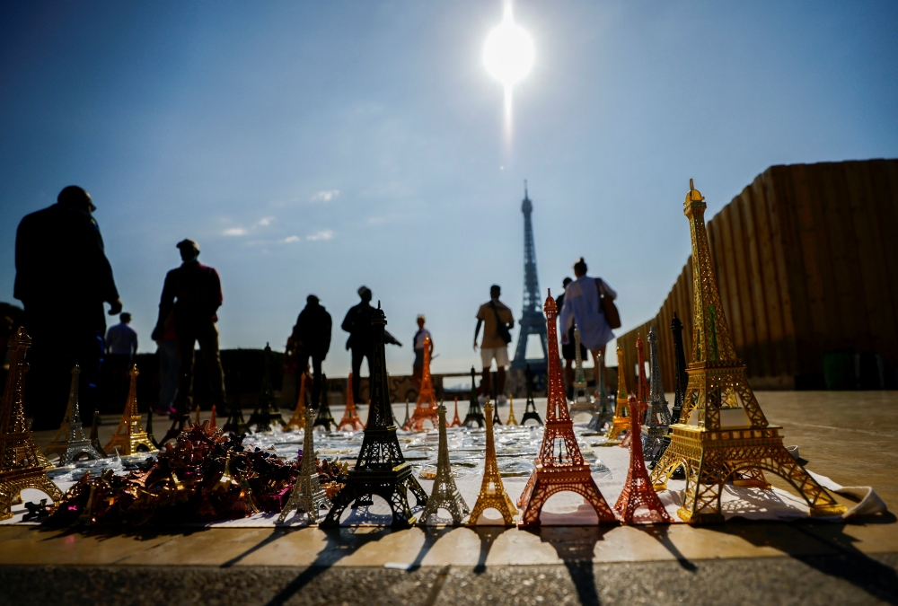 Tourists walk at Trocadero square near the Eiffel Tower and miniatures of it on a warm and sunny day in Paris, France, September 3, 2021. REUTERS/Eric Gaillard
 