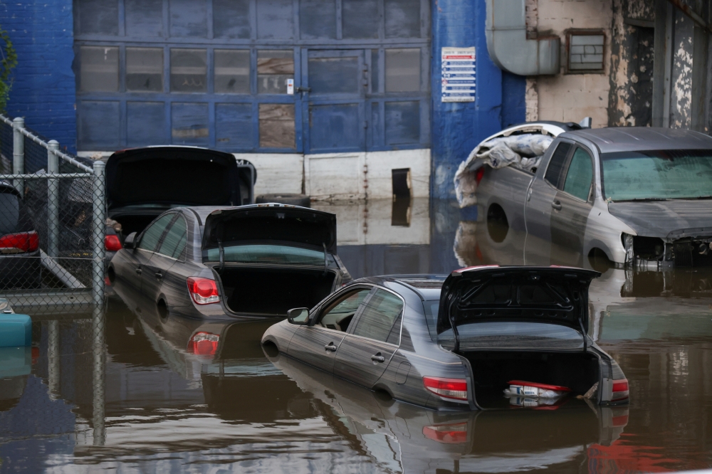 FILE PHOTO: Cars sit in water after flooding on the Major Deegan Expressway spilled over into the neighboring street and flooded a parking lot, when the remnants of Tropical Storm Ida brought drenching rain and the threat of flash floods and tornadoes to 