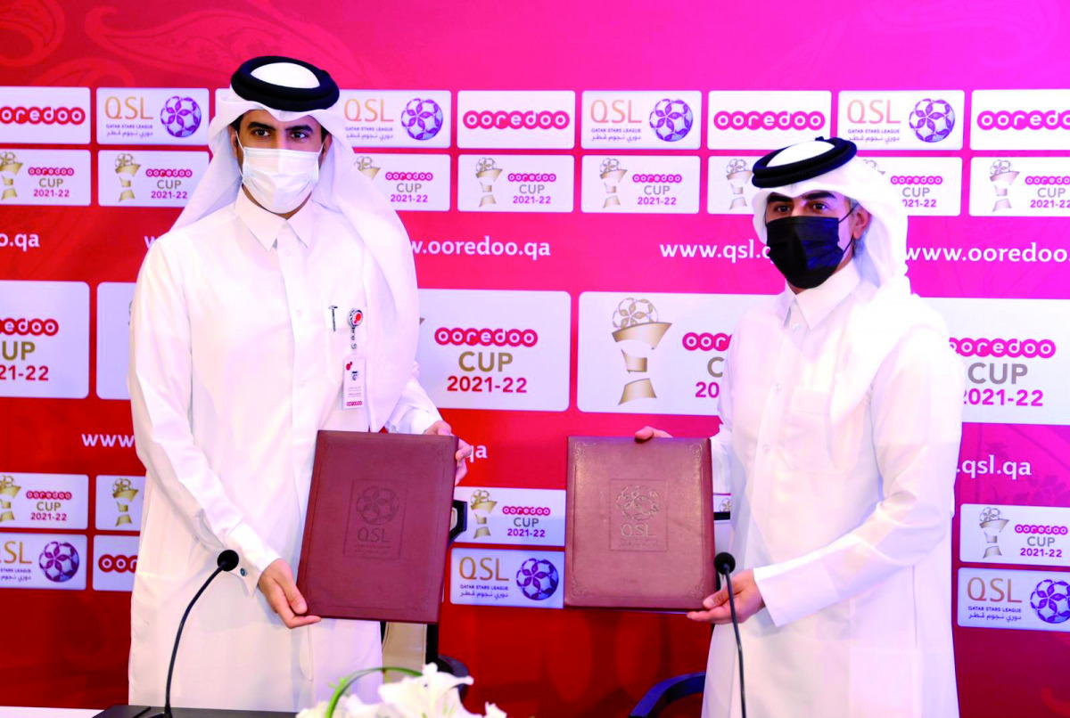 Qatar Stars League's (QSL) Executive Director of Sales, Marketing and Communication, Hassan Rabia Al Kuwari exchanges documents with Executive Director Business at Ooredoo, Thani Al Malki, during a sponsorship signing ceremony held in Doha. QSL and Ooredo