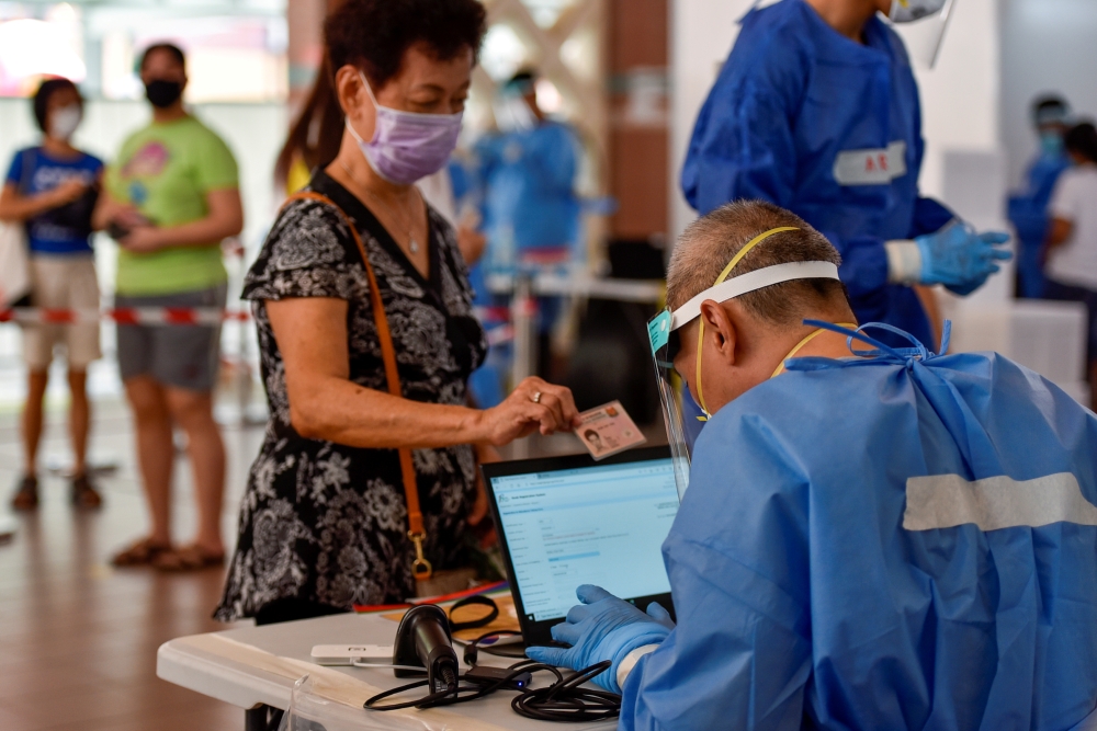 Swab tests are conducted at a public housing estate after a nearby food centre became a coronavirus disease (COVID-19) cluster, in Singapore, June 16, 2021. REUTERS/Caroline Chia/File Photo