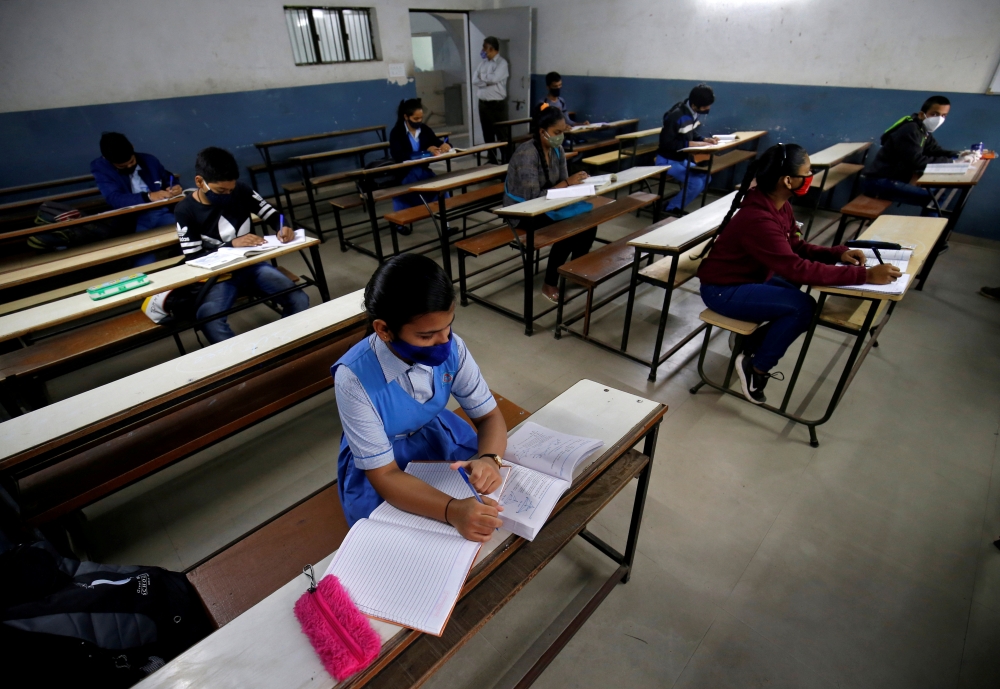 Students wearing protective face masks attend their class as they maintain social distancing in Ahmedabad, India, January 11, 2021. Reuters/Amit Dave/File Photo