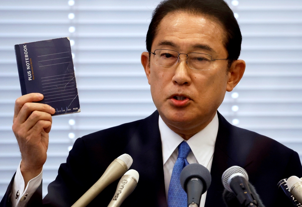 File photo: Fumio Kishida, Japan's ruling Liberal Democratic Party (LDP) lawmaker and former foreign minister, shows his notebook during a news conference as he announces his candidacy for the party's presidential election in Tokyo, Japan August 26, 2021.