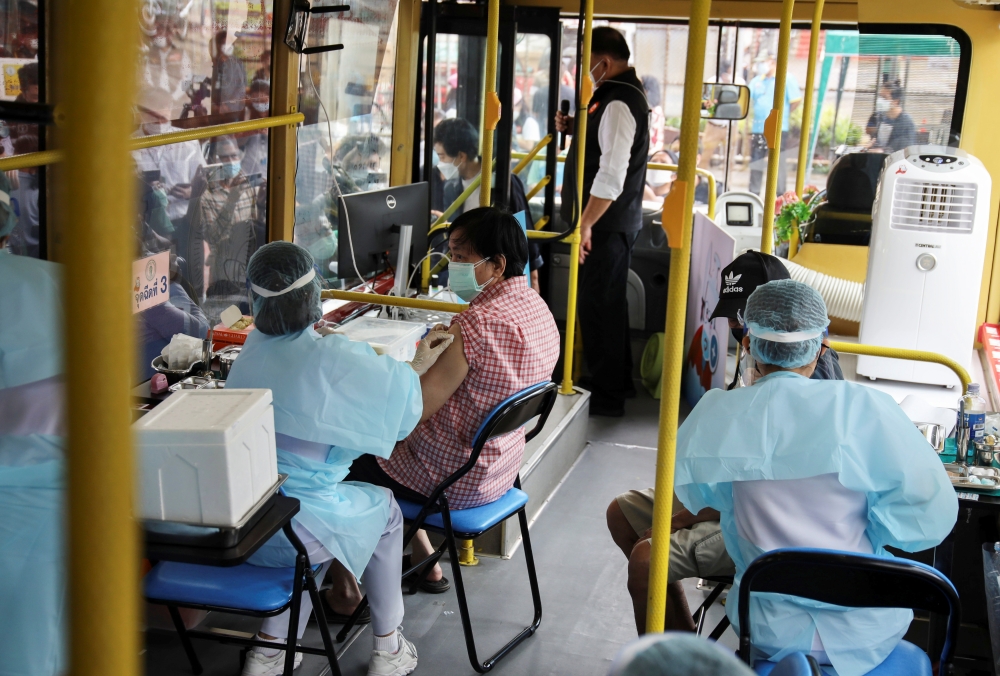 A woman receives a jab of the coronavirus disease (COVID-19) vaccine inside a mobile vaccination bus set-up to serve the elderly and disabled groups in Bangkok, Thailand, September 8, 2021. REUTERS/Juarawee Kittisilpa