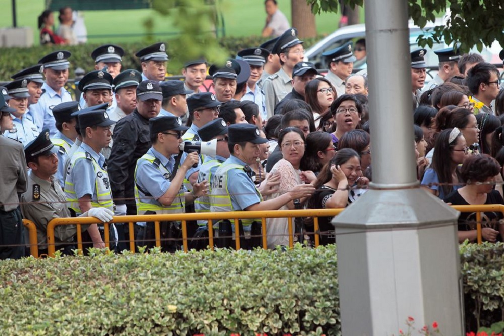 Police officers remove fans standing outside the opening ceremony of the 17th Shanghai International Film Festival, June 14, 2014. REUTERS/Aly Song (CHINA - Tags: ENTERTAINMENT)