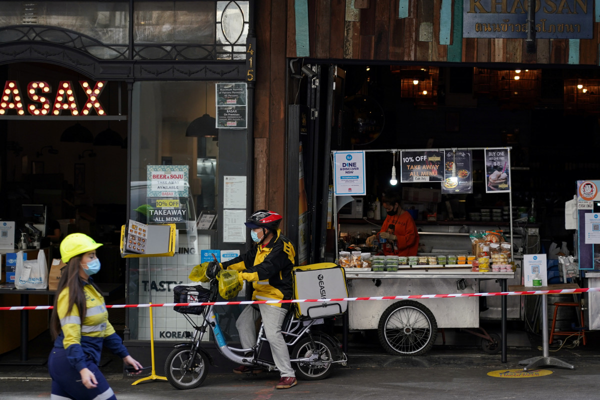 (From L) A construction worker, delivery courier and restaurant staff wear protective face masks while working in the city centre during a lockdown to curb the spread of a coronavirus disease (COVID-19) outbreak in Sydney, Australia, September 9, 2021. RE