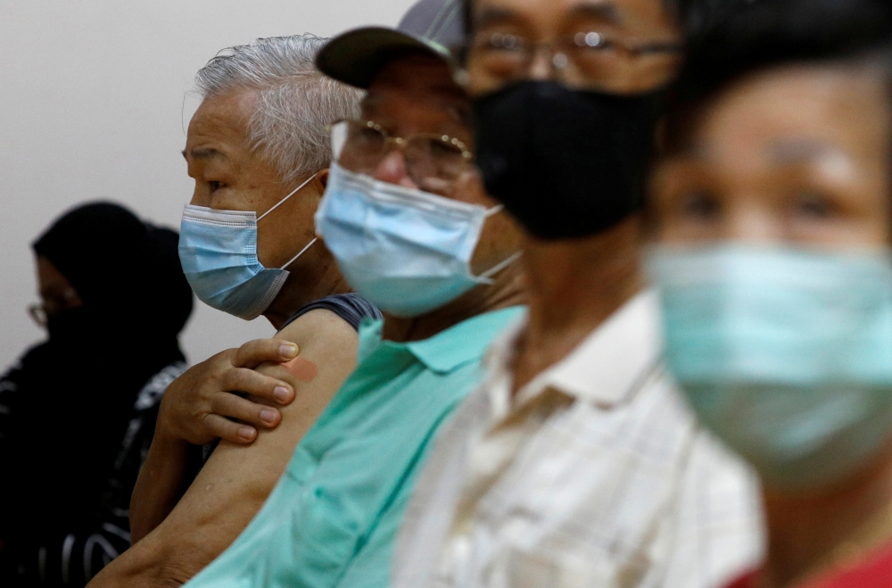 People wait at an observation area after their vaccination at a coronavirus disease (COVID-19) vaccination center in Singapore March 8, 2021. REUTERS/Edgar Su/File Photo
