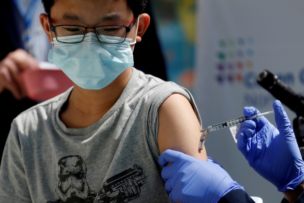 Brendan Lo (13) receives a dose of the Pfizer-BioNTech vaccine for the coronavirus disease (COVID-19) at Northwell Health's Cohen Children's Medical Center in New Hyde Park, New York, U.S., May 13, 2021. Reuters/Shannon Stapleton/File Photo