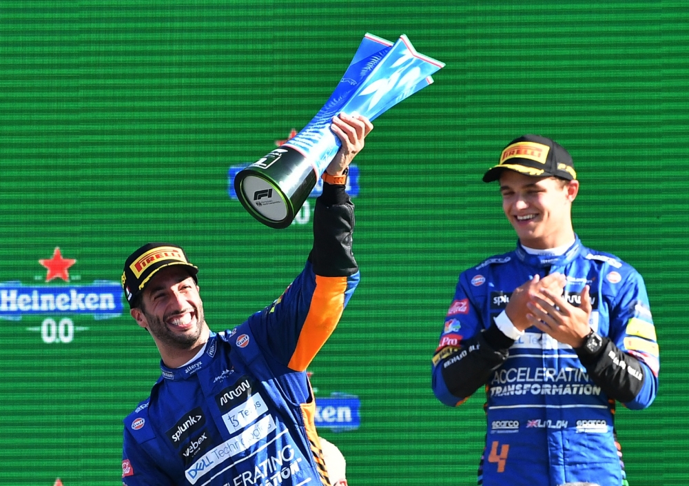 McLaren's Daniel Ricciardo celebrates with the trophy on the podium with after winning the race alongside second place McLaren's Lando Norris REUTERS/Jennifer Lorenzini