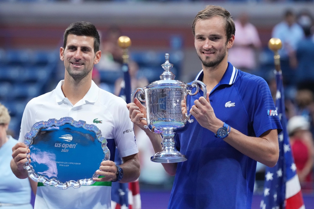 (L-R) Novak Djokovic of Serbia and Daniil Medvedev of Russia celebrate with the finalist and championship trophies, respectively, after their match in the men's singles final on day fourteen of the 2021 U.S. Open tennis tournament at USTA Billie Jean King
