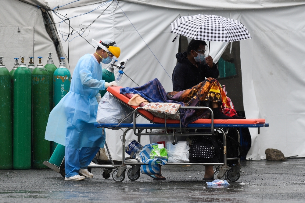 A health worker wearing personal protective equipment (PPE) as protection against the coronarivus disease (COVID-19) transports a suspected COVID-19 patient, at Sta. Ana Hospital, in Manila, Philippines, September 8, 2021. REUTERS/Lisa Marie David/File Ph