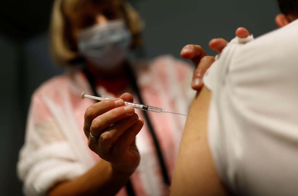 A medical worker administers a dose of the 