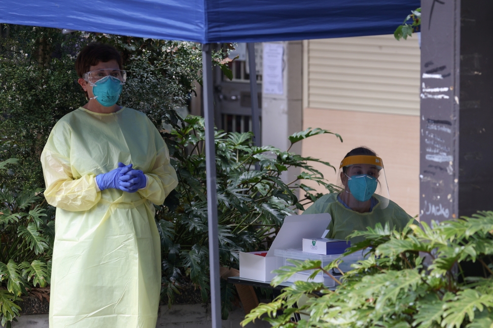 Health workers provide coronavirus disease (COVID-19) testing to residents of surrounding public housing towers in the Redfern suburb, where authorities are working to contain an emerging cluster of cases, as a widespread lockdown continues in Sydney, Aus