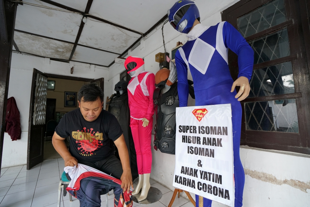 Agus Widanarko, 40, puts on a Spiderman costume as he prepares to entertain children confined to their homes due to coronavirus disease (COVID-19) restrictions, in Sukoharjo, Central Java province, Indonesia, September 10, 2021. REUTERS/Stringer