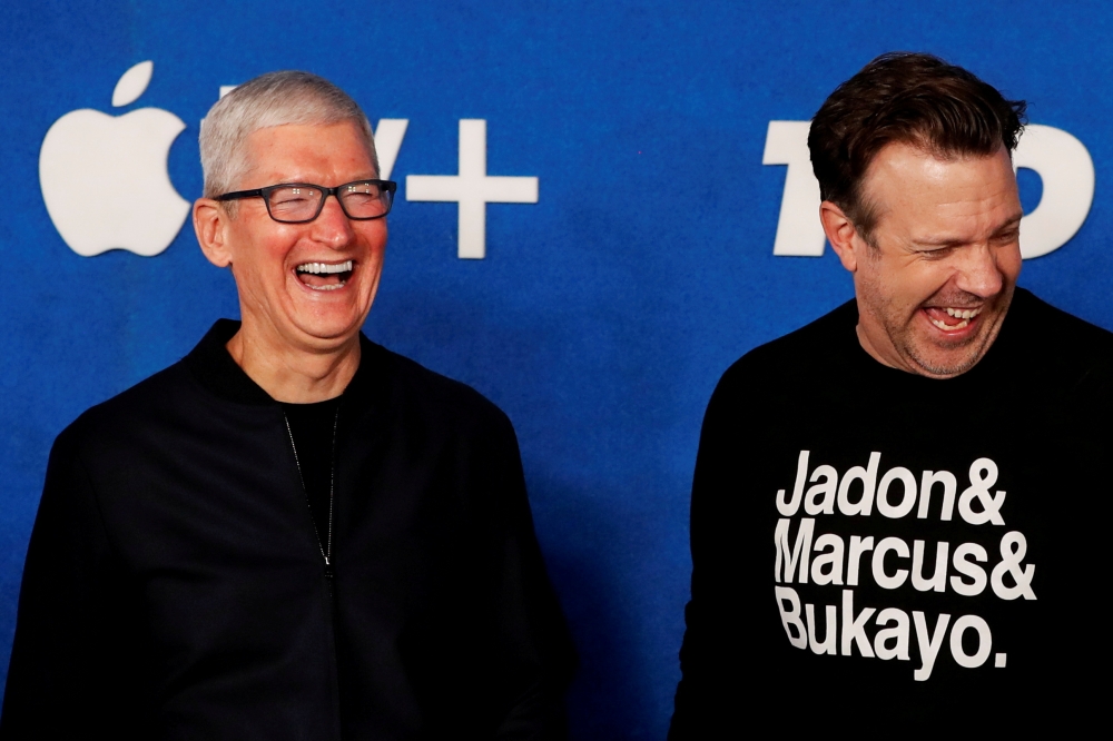 Apple CEO Tim Cook and cast member Jason Sudeikis share a laugh at the premiere for season two of the television series 