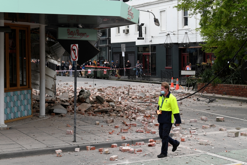 A person walks past damage to the exterior of a restaurant following an earthquake in the Windsor suburb of Melbourne, Australia, September 22, 2021. AAP Image/James Ross via REUTERS