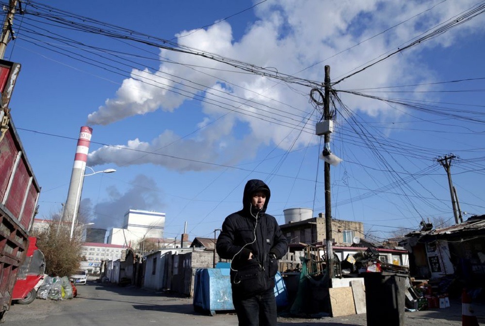 A man walks near a coal-fired power plant in Harbin, Heilongjiang province, China November 27, 2019. REUTERS/Jason Lee

