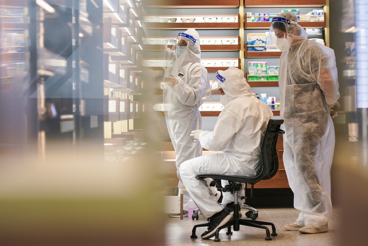 Members of a cleaning crew wearing personal protective equipment (PPE) work inside a closed shop in the city centre during a lockdown to curb the spread of a coronavirus disease (COVID-19) outbreak in Sydney, Australia, September 24, 2021. REUTERS/Loren E