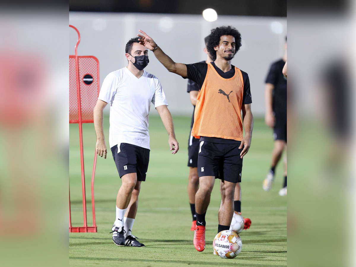 Al Sadd's coach Xavi Hernandez (left) and striker Akram Afif during a practice session yesterday.
