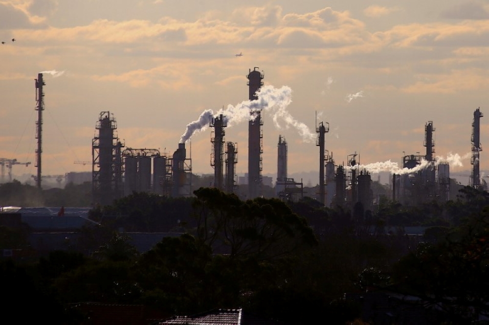 File photo: Birds and a plane are seen flying above emission from the chimneys of a chemical plant located near Port Botany in Sydney, Australia June 2, 2017. Reuters/David Gray/File Photo
