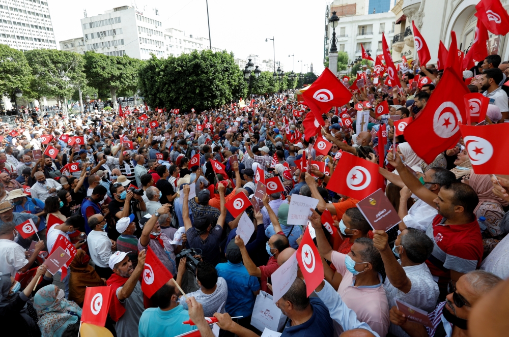 Demonstrators carry flags and banners during a protest against the Tunisian President Kais Saied's seizure of governing powers, in Tunis, Tunisia, September 26, 2021. REUTERS/Zoubeir Souissi