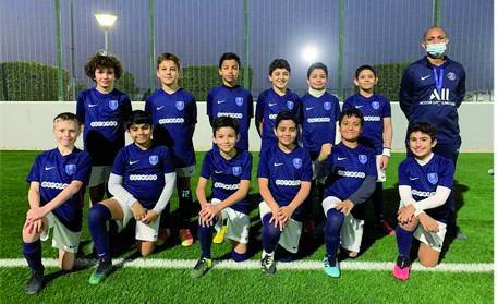 PSG Academy U-12 team players with an official.
