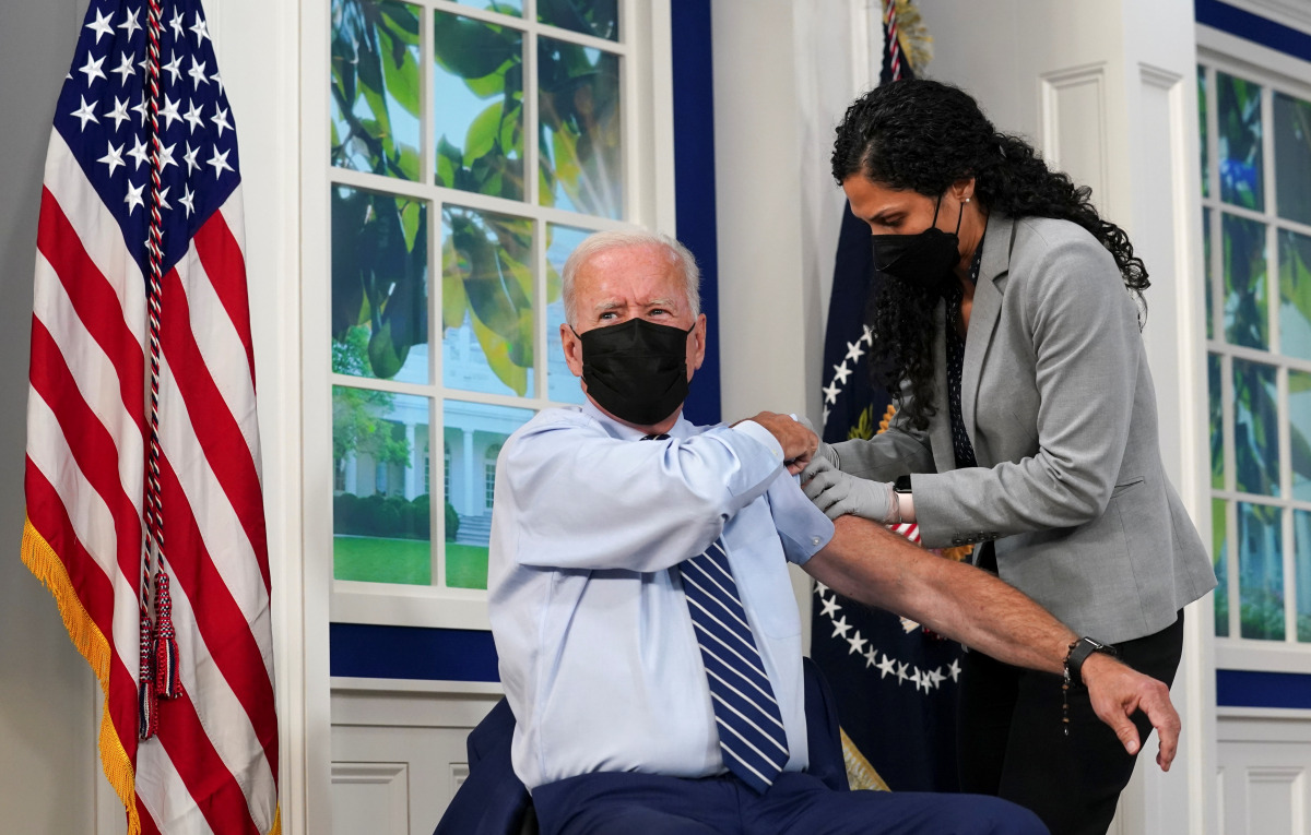 U.S. President Joe Biden holds up his sleeve to receive his coronavirus disease (COVID-19) booster vaccination in the Eisenhower Executive Office Building's South Court Auditorium at the White House in Washington, U.S., September 27, 2021. REUTERS/Kevin L