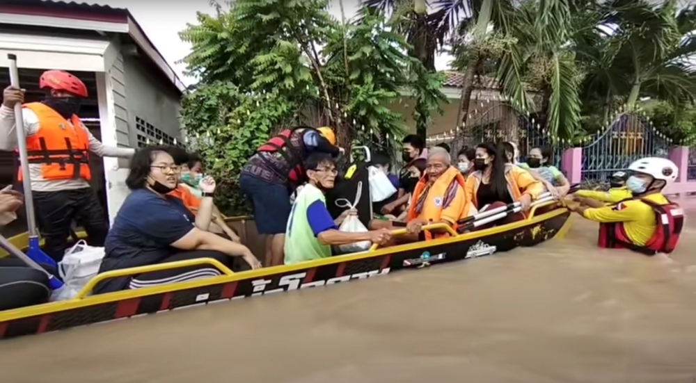Flood victims sit on a boat after they were rescued amid severe flooding in the Chaiyaphum province, Thailand, in this screen grab taken from a video from social media September 28, 2021. Hook31 Thailand/via Reuters 