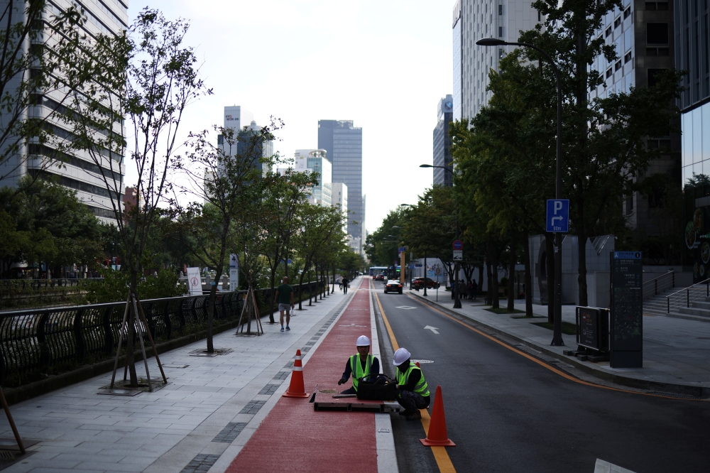 People work on an empty street in Seoul, South Korea, September 30, 2021. REUTERS/Kim Hong-Ji