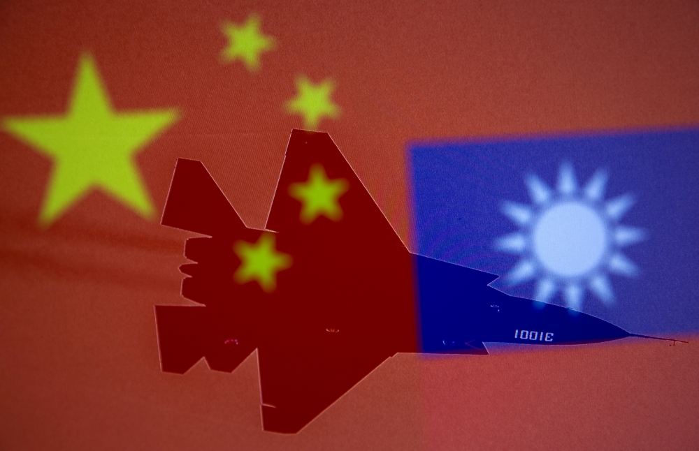 File photo: Chinese and Taiwanese national flags are displayed alongside a military airplane in this illustration taken April 9, 2021. Reuters/Dado Ruvic/Illustration/File Photo
 